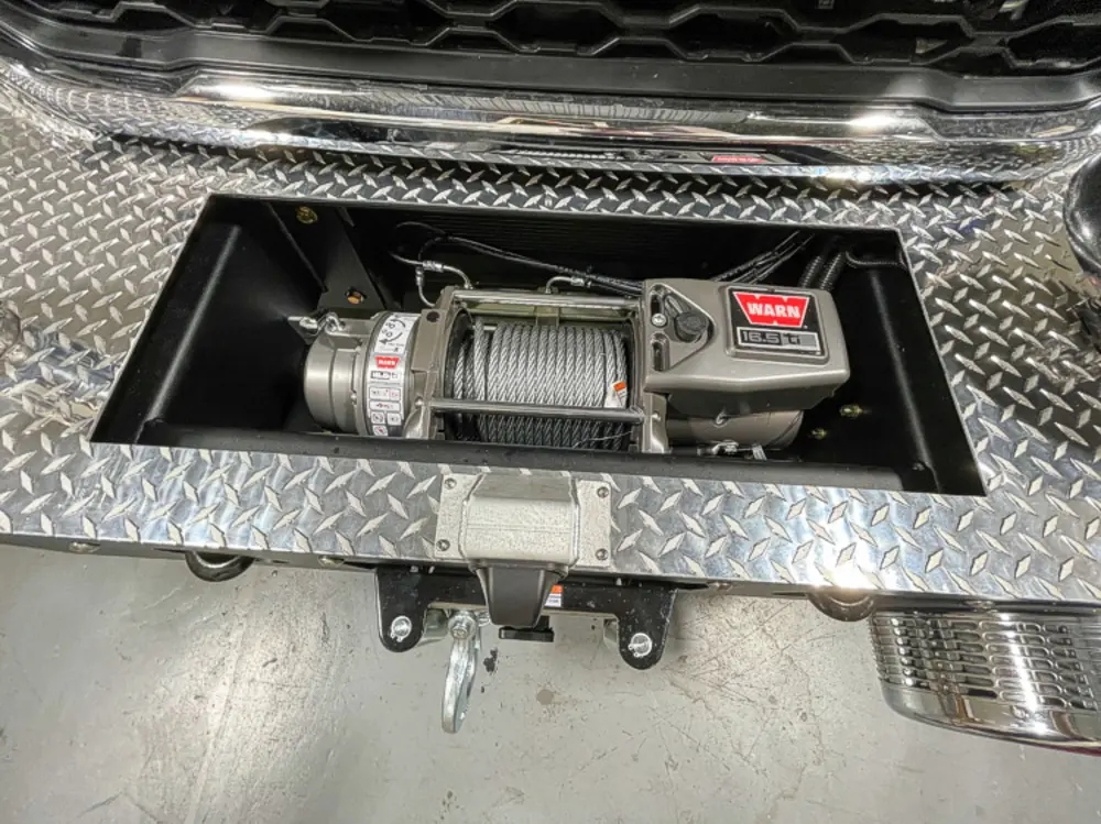 Exterior view of small fire truck showing cab, body compartments, and wheel/tire area.